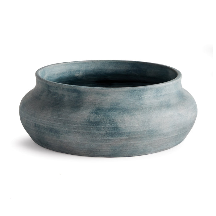 A large round ceramic decorative bowl with a muted blue-gray glaze and a wide, curved tapered rim, set against a white