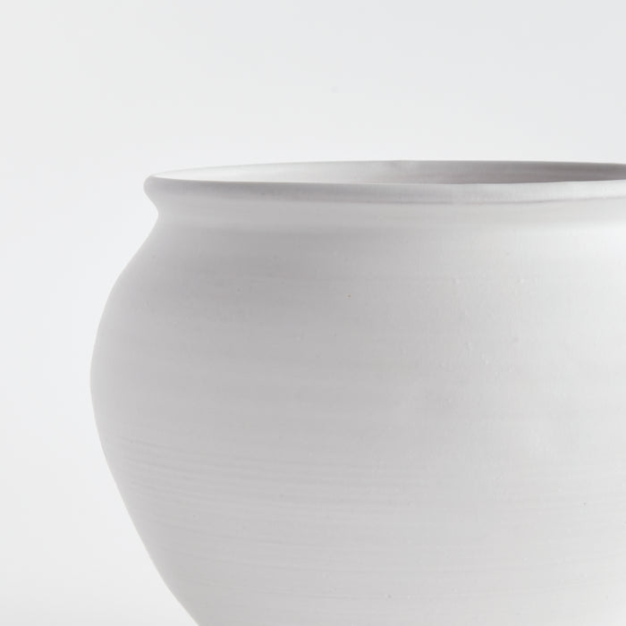 Large white ceramic drum vase with smooth matte finish on light background