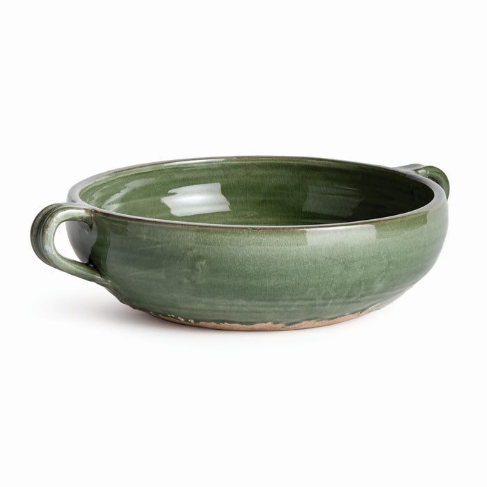 Green glazed ceramic decorative bowl with two small loop handles, shallow oval shape, slightly crackled finish, on a light