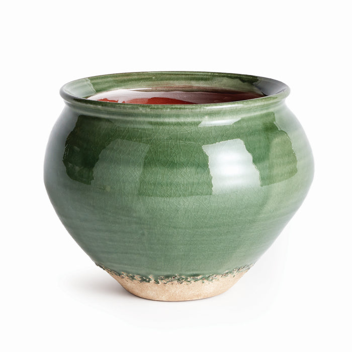 Green glazed ceramic drum vase with a rounded body, narrow mouth, visible crackle glaze, and unglazed tan base.