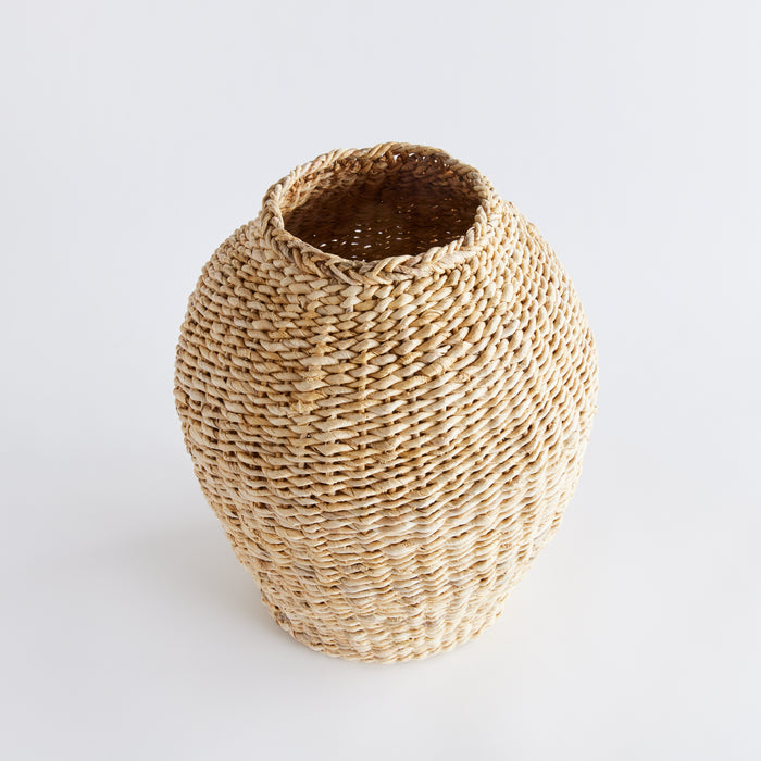 Small teardrop vase woven from natural abaca fibers with an open top, neutral beige tones, against a plain white backdrop.