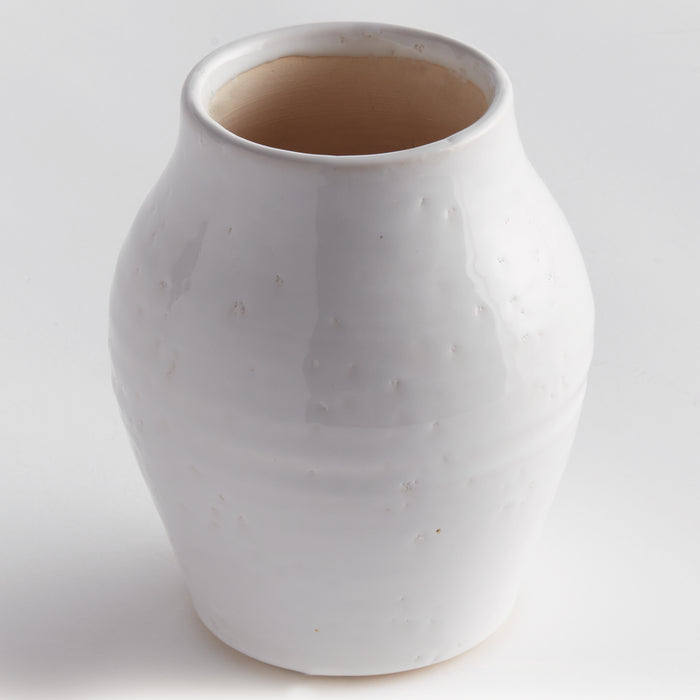 White glazed ceramic narrow vase with a rounded, bulbous body and small imperfections; light beige inner rim; set against a