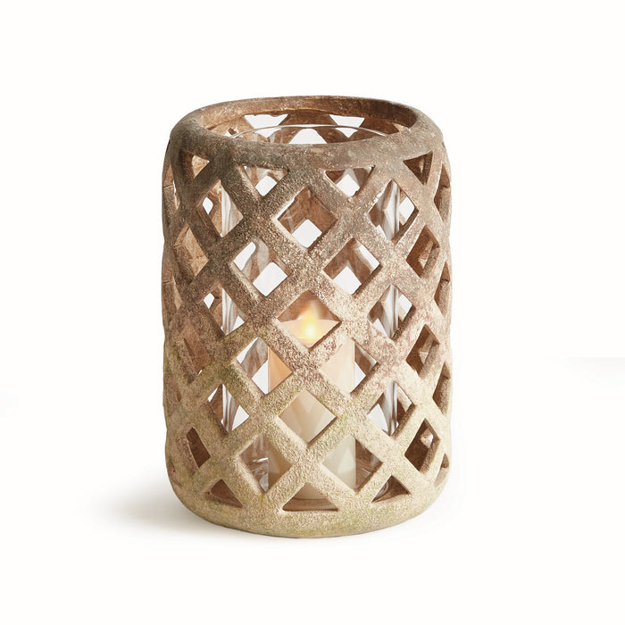 A terracotta-colored ceramic hurricane candle holder with a geometric pattern and a lit candle inside, placed on a white background.