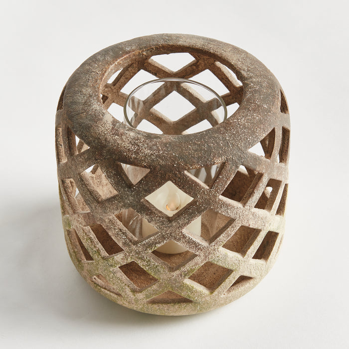Rustic brown lattice hurricane lantern with white candle inside; ceramic lattice outer cage, circular top handle, neutral