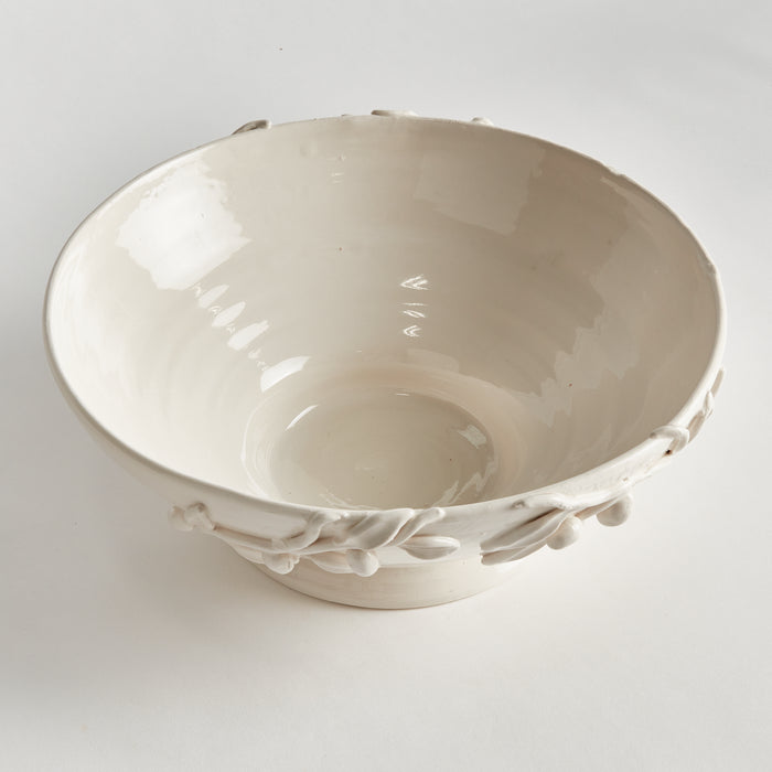 Olivella white ceramic footed bowl with floral leaf embellishments along rim, smooth glossy interior and small pedestal base.