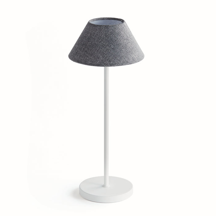 A cordless LED lamp with an empire linen shade, standing on a white base, against a white background.