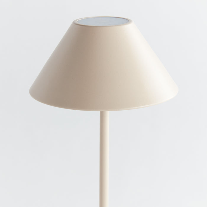 Beige cordless LED lamp with a conical lampshade on a slim rod, neutral background.