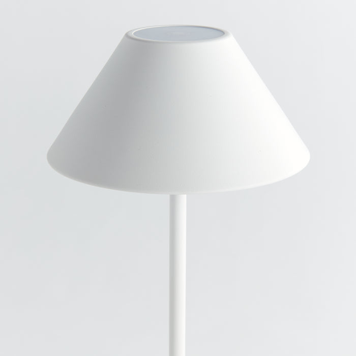 White cordless LED lamp with conical fabric shade and slim cylindrical stand against a light background.