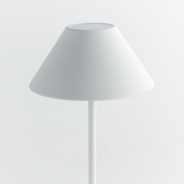 White cordless LED lamp with a conical shade on a slim vertical stand, minimalistic modern design against a plain white