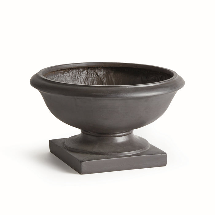 A dark gray, round, outdoor footed bowl made of concrete composite material, placed on a square base.