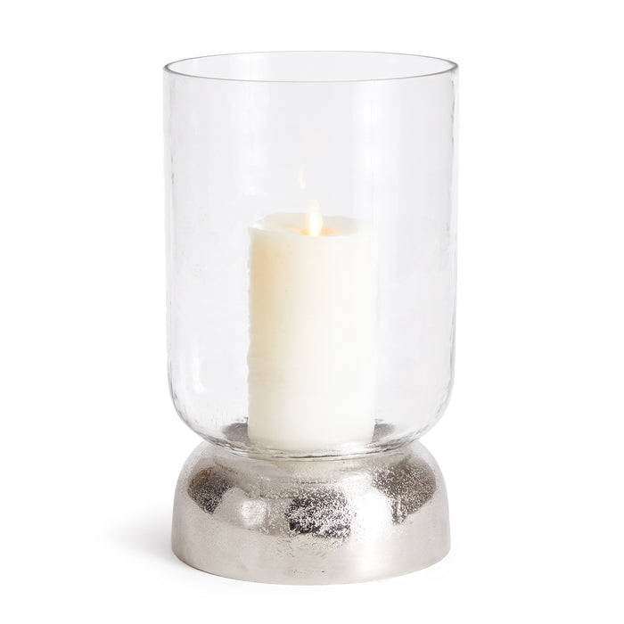A clear glass hurricane with a chrome finish base, designed to hold a candle.
