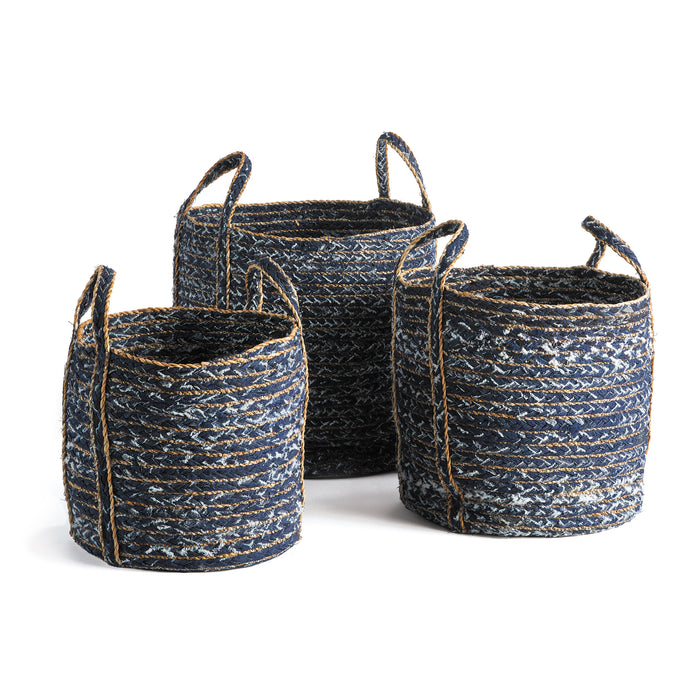 A set of three round denim baskets in varying shades of blue with brown handles, placed against a white background.