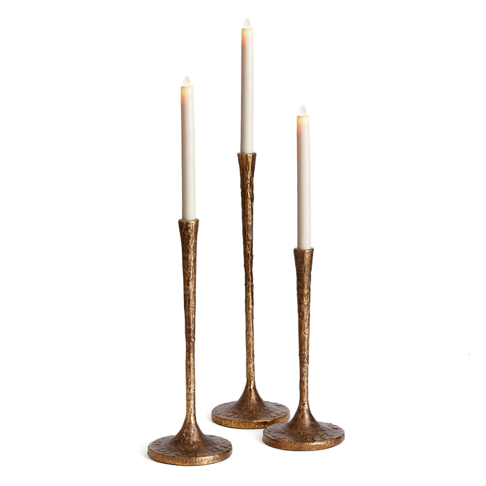 A set of three brown tapered candle holders with a textured finish, displayed against a white background.