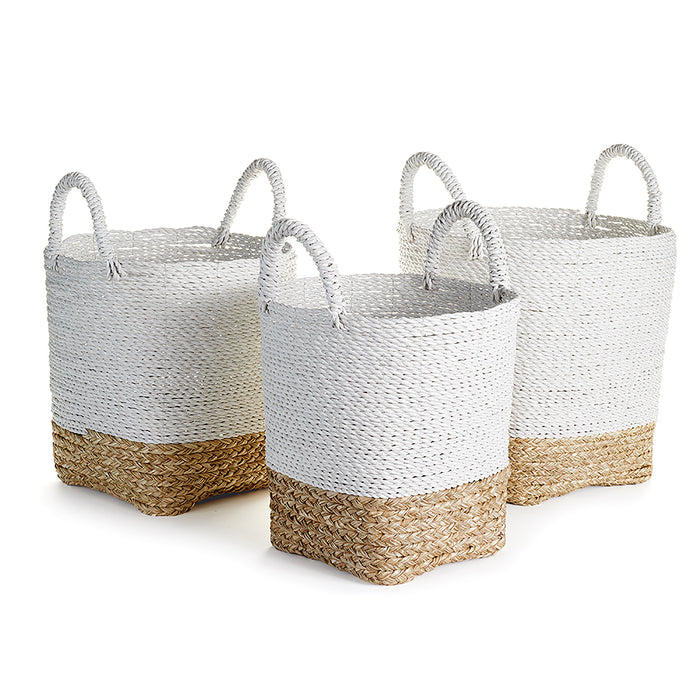 A set of three white wicker market baskets with natural weaves and brown accents, each with a sturdy handle.