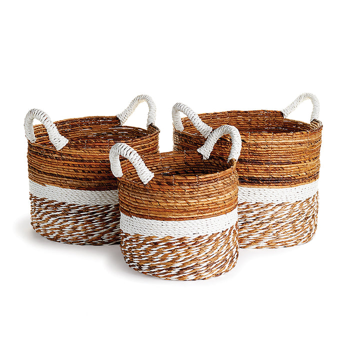 A set of three round wicker baskets with brown and beige stripes, featuring white handles.