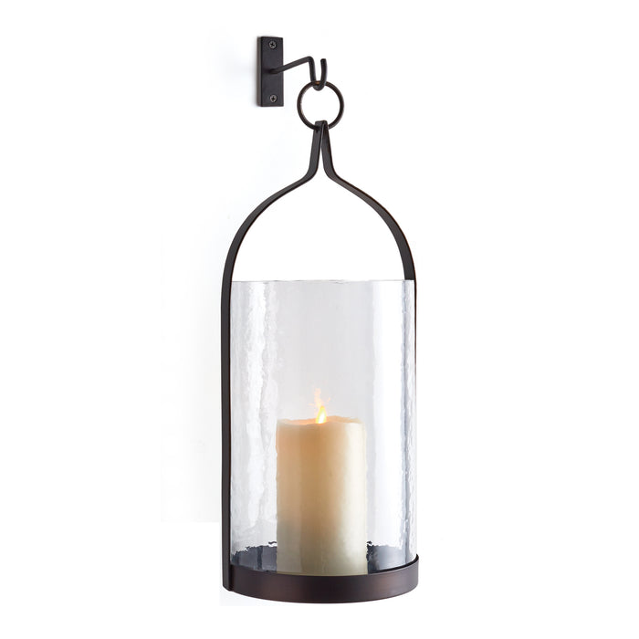 A clear glass lantern with a black iron frame and a candle inside, designed for indoor use.