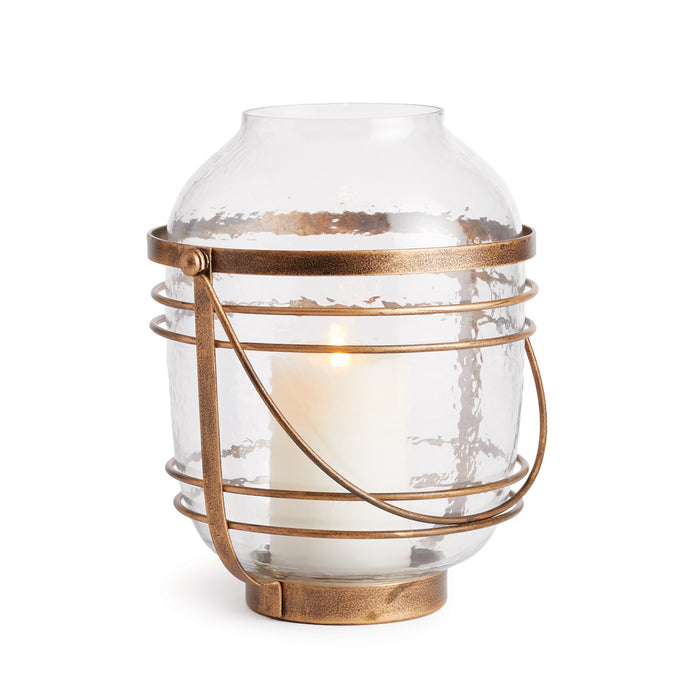 A large clear glass hurricane with a bronze-colored iron base, designed for holding a candle.