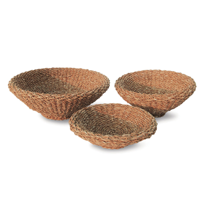 A set of three beige seagrass shallow tapered baskets, placed on a white background.