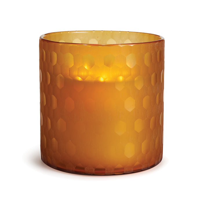 A thick glass hurricane-style candle holder in a deep jewel tone with a geometric pattern.