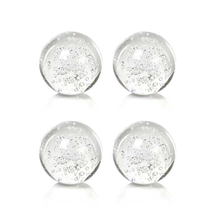 Four clear glass marbles with embedded bubbles on a white background