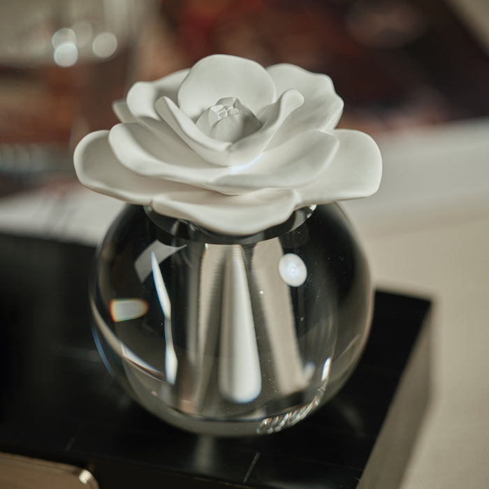 Decorative diffuser with a white ceramic flower on top