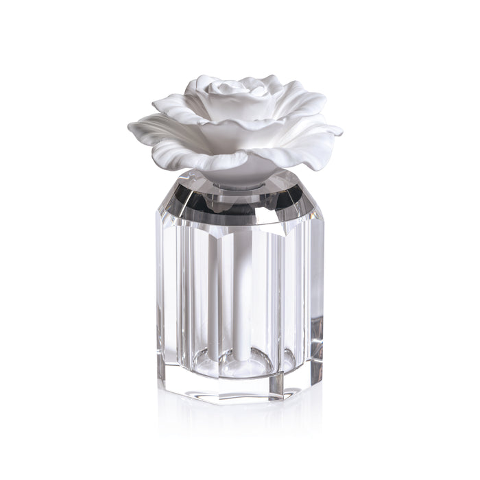 A clear crystal-shaped porcelain diffuser with a white porcelain flower top.