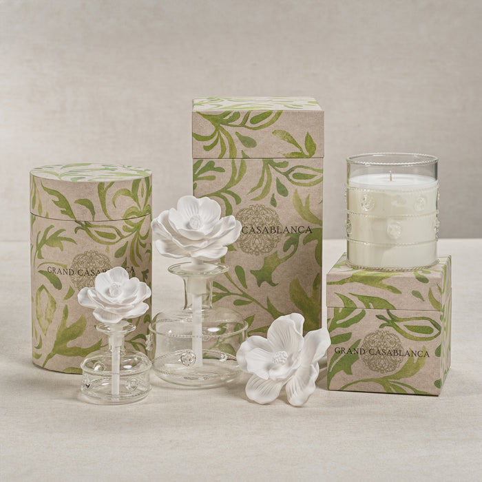 Decorative candles and containers with floral designs and 'Casablanca' branding on a neutral background.