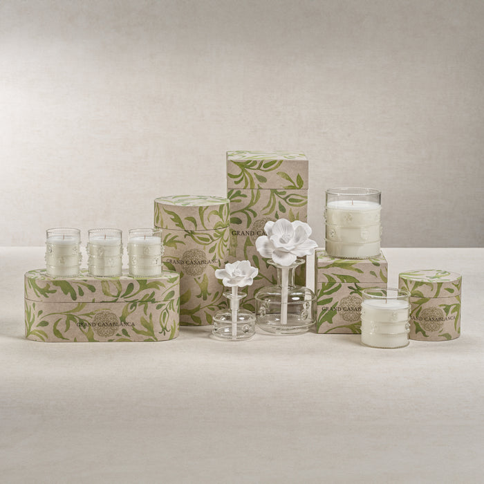 Candle holders and boxes with floral design on a neutral background