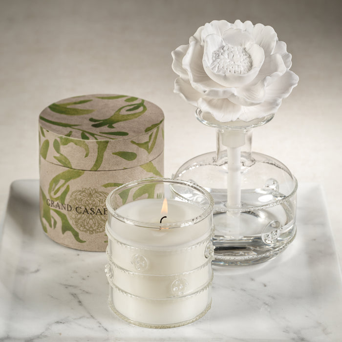 A vintage-styled porcelain diffuser with a floral design, displayed next to its packaging box, on a marble surface.