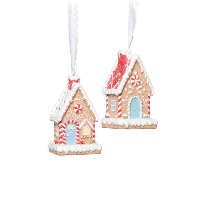 Two gingerbread house ornaments on white ribbons against a white background