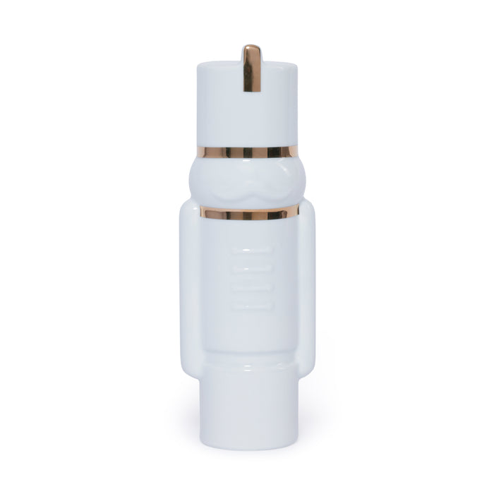White cylindrical object with gold accents on a white background