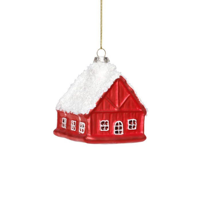 Red house-shaped ornament with white snow on a white background