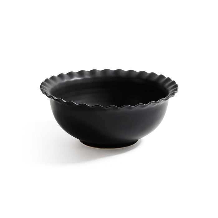 Black ceramic bowl with wavy rim on a white background