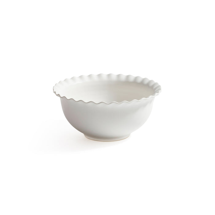 White ceramic bowl with scalloped edge on a white background
