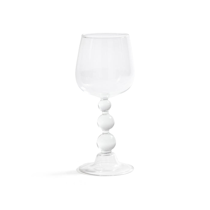 Clear glass wine glass with white cylindrical stem on a white background