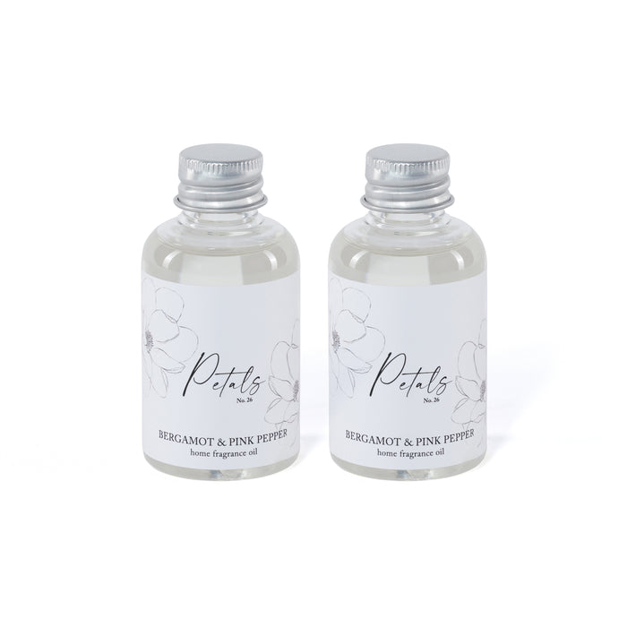 Two bottles of Petals home fragrance oil with silver caps on a white background