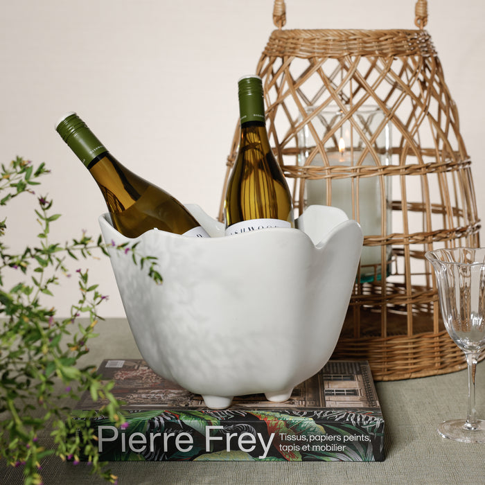 White marble wine cooler with bottles on a book, wicker basket in the background