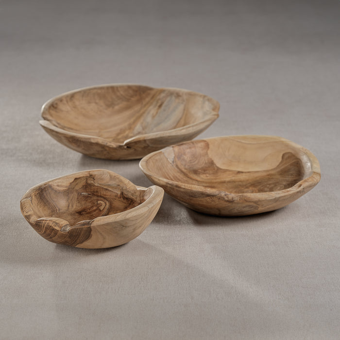 Three natural teakwood bowls of varying sizes placed on a neutral surface.