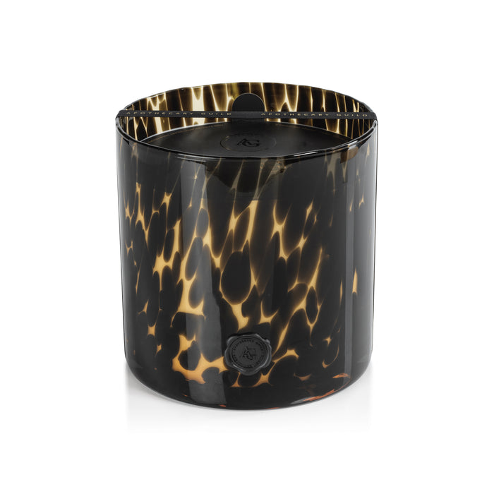 Opal glass candle jar with black and amber tortoise pattern, black lid, round AG emblem, dark interior, against white