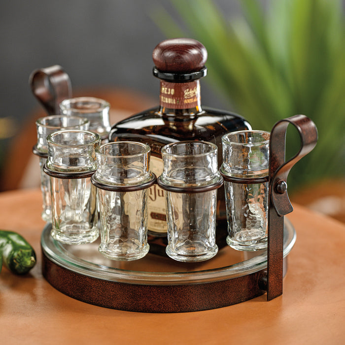 Bottle of Johnnie Walker Blue Label whisky with a set of shot glasses on a wooden stand.