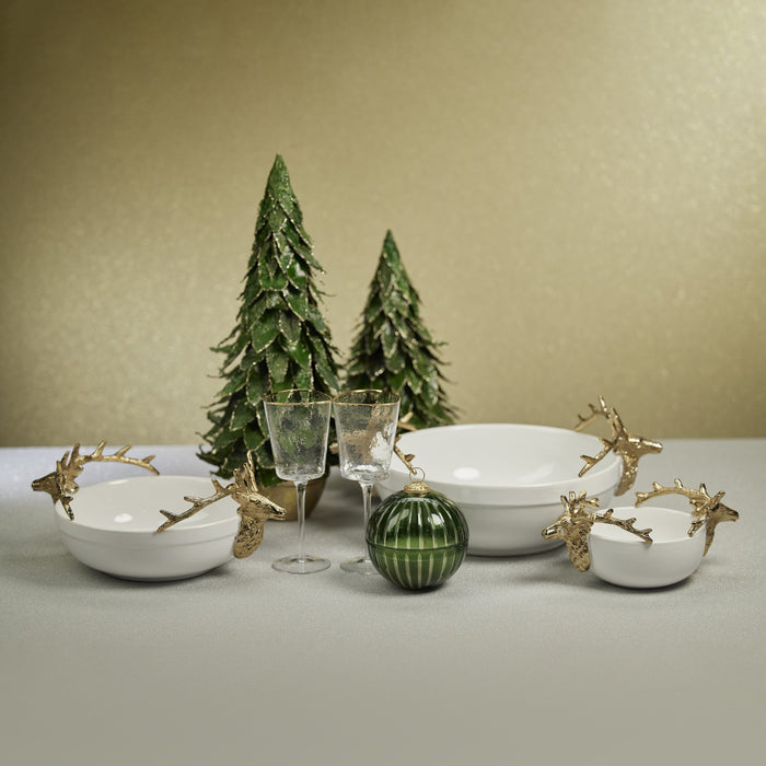 White ceramic bowls with gold-stag handles, two green striped ornament, two champagne flutes, and green Christmas tree decor