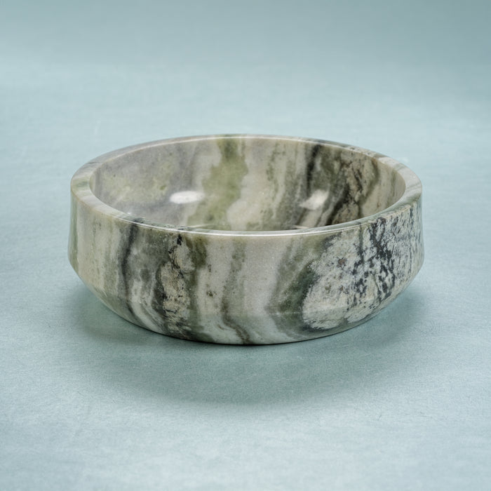 Marble-patterned ceramic bowl on a light blue background