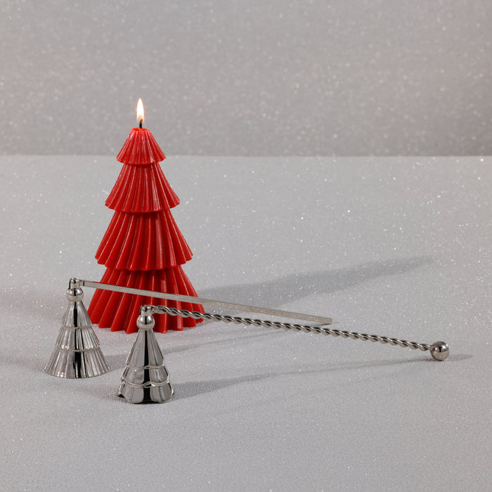 Red tree-shaped candle with a silver candle snuffer on a gray background