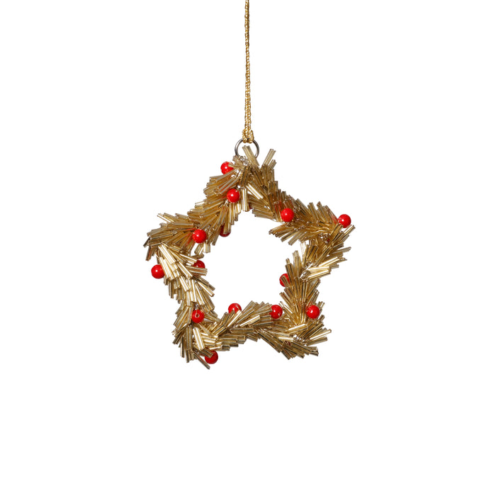 Decorative gold star-shaped ornament with red berries on a white background