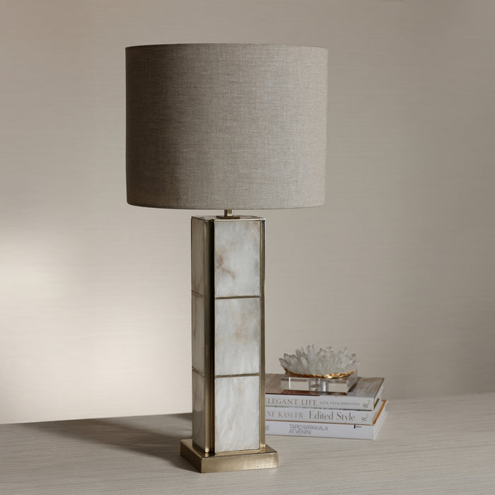 Table lamp with a marble base on a wooden surface against a beige wall
