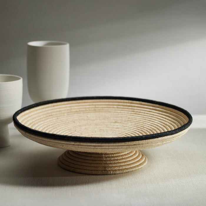 Woven basket on a stand with white cups in the background