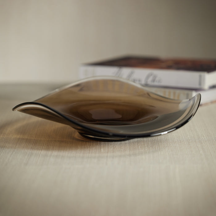 Glass bowl on a textured surface with a blurred book in the background