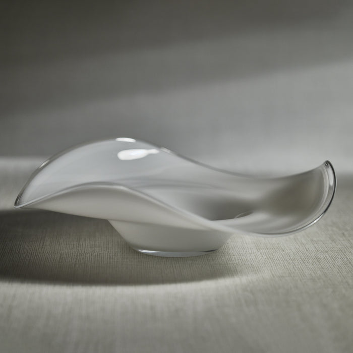 Glass sculpture with wavy design on a textured surface