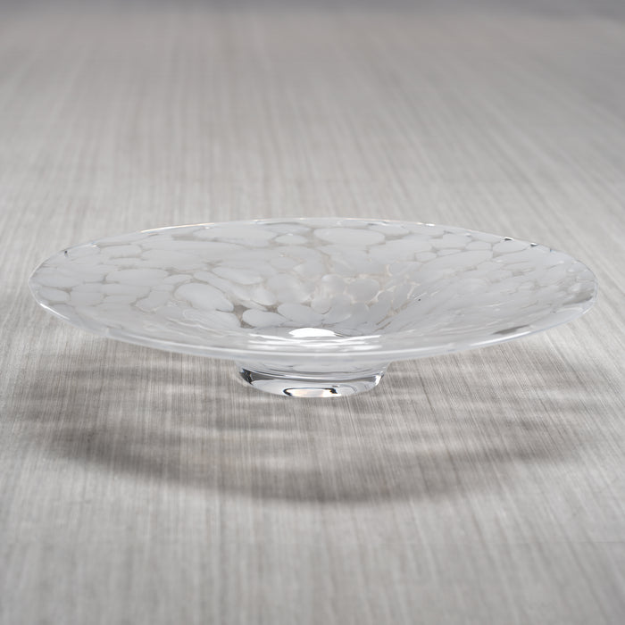 A handblown white glass decorative bowl with a confetti design, featuring white speckles, displayed on a wooden surface.