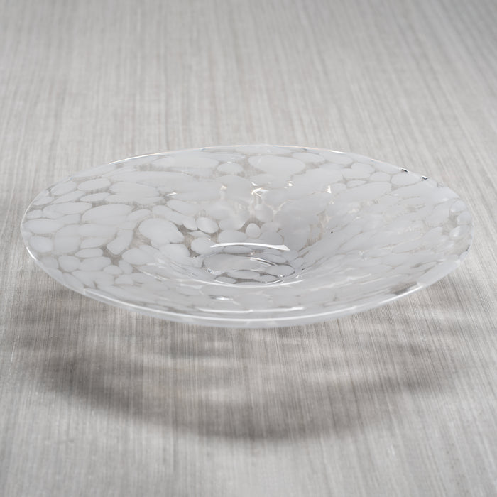 Confetti white glass bowl with clear translucent surface, shallow curved dish on neutral textured background.